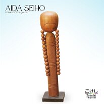 Aida Seihō (相田 晴峰) Osage - Pigtails A simple yet elegant Kokeshi doll design by this artist. The natural wood grain flowing like bangs across the forehead delicately beveled to...
