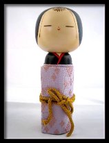 Sayonara Doll A beautifully crafted sayonara doll. The pink silk fabric covered roll of paper is wrapped securely around the body of this Kokeshi and then tied with a golden...